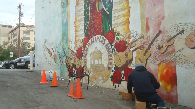 Artist working on a mural just off the plaza.